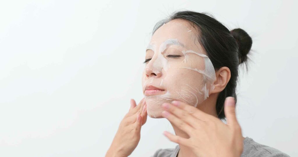 Woman apply paper mask skin care