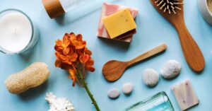Skin care and aromatherapy objects laid out flat on a sky-blue countertop.