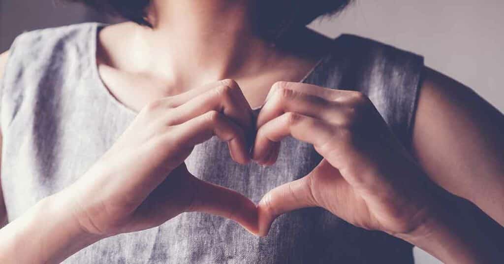 Young woman making her hands in heart shape.