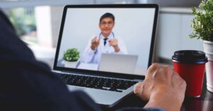 Doctor explaining to patient via laptop computer for telemedicine and medical online e-health consultation.