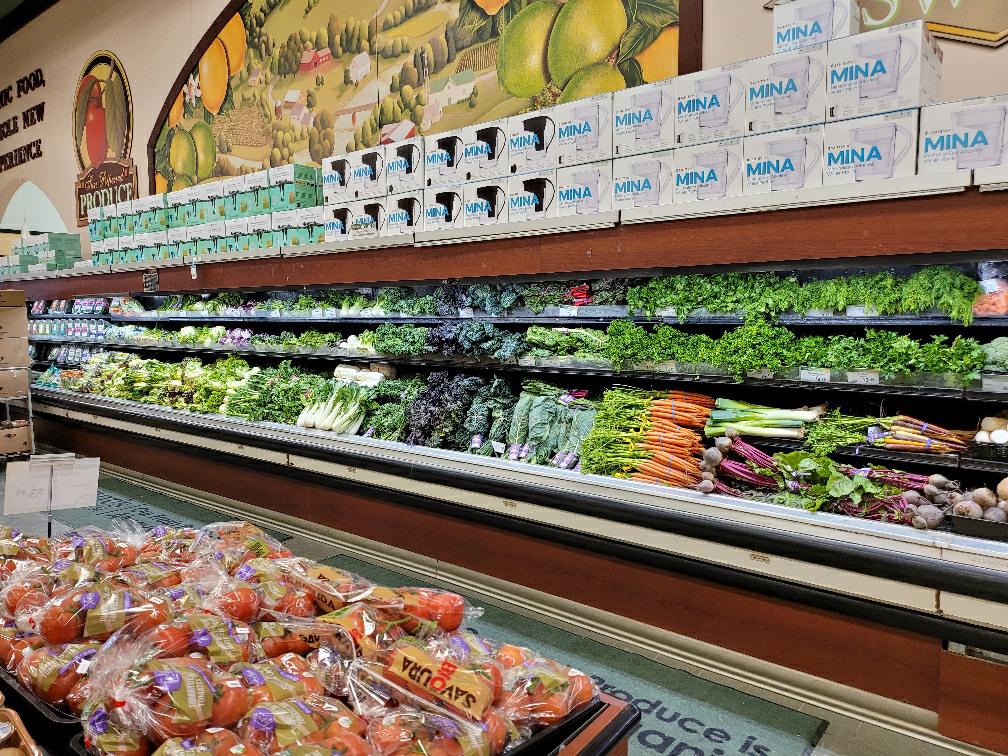 A large produce display of different fruits and vegetables in a grocery store.